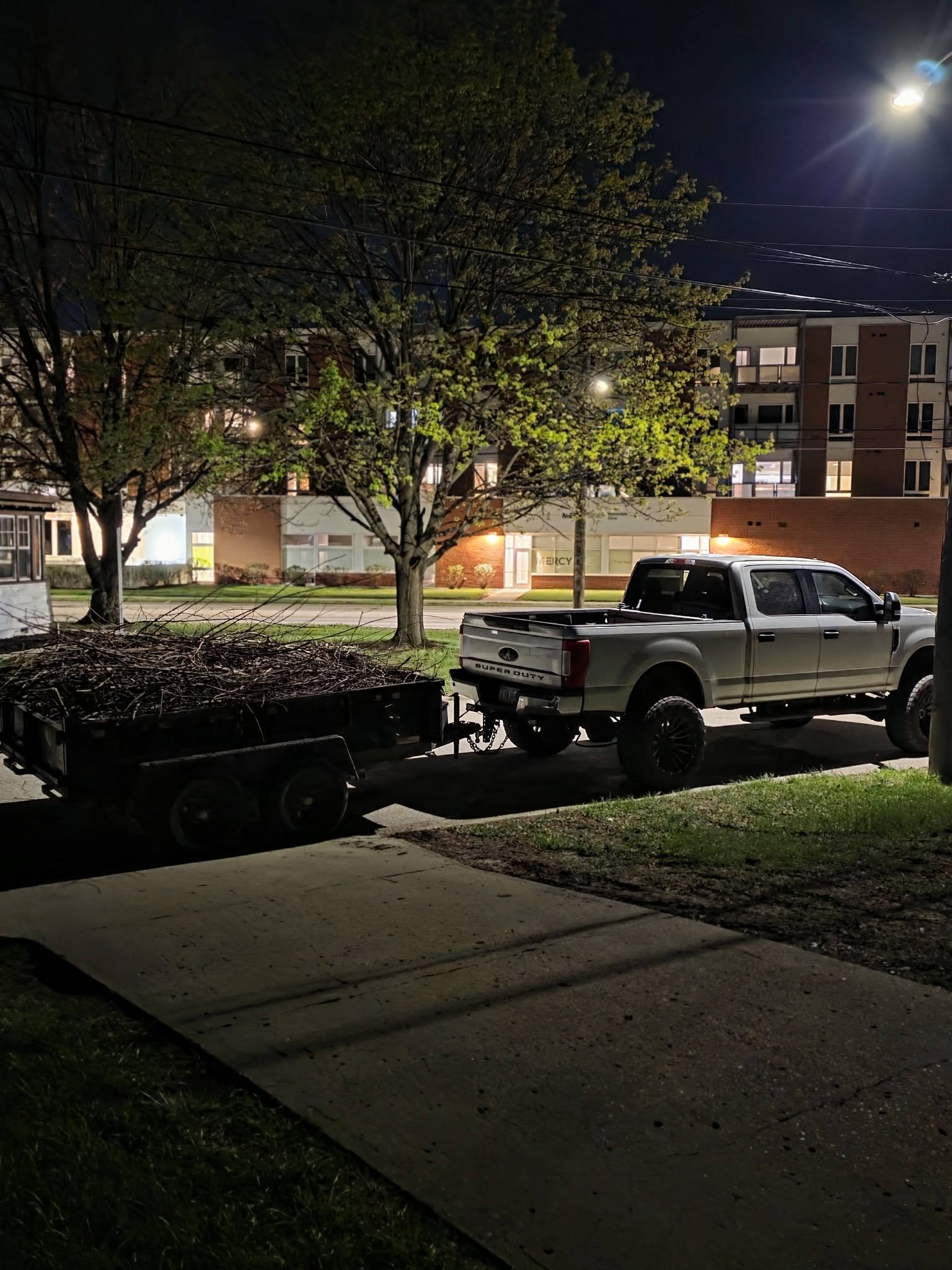 Truck and loaded trailer on the street at night after a job